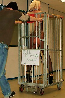 Bondage doll is put in a cage and ready for be delivered to a new owner after the auction